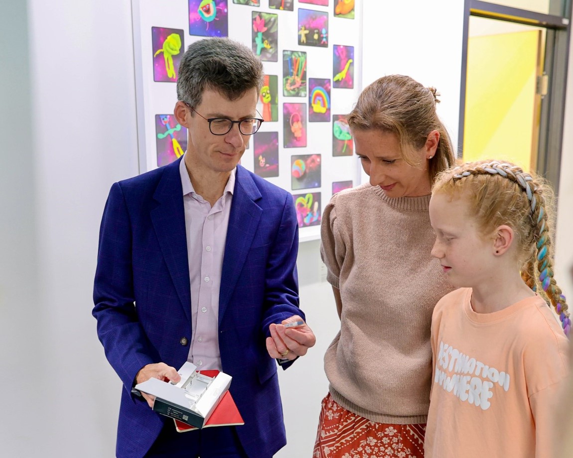 Prof Chris Blyth shows 10-year-old Elsie and her mum, Casey, the new FluMist.